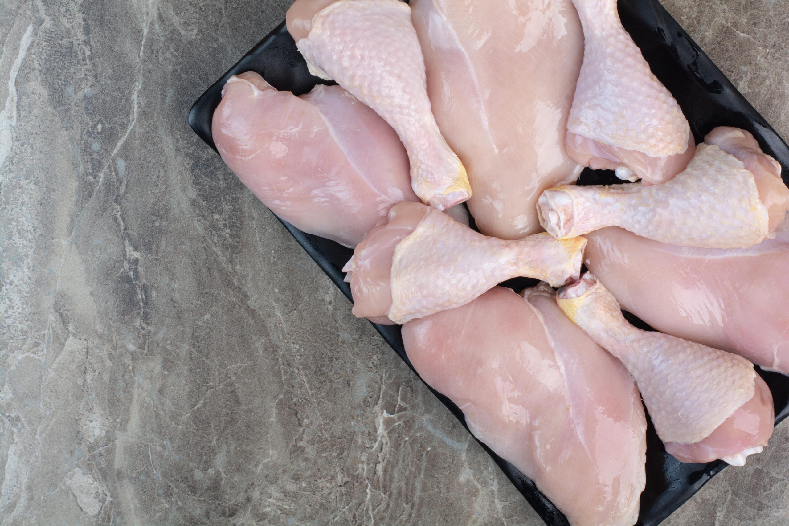 Fresh unprepared chicken legs on dark plate. High quality photo